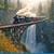 Vintage-train-crossing-over-waterfall-steam-locomotive-crosses-wooden-trestle-high-above-waterfall-surrounded-lush-370652351